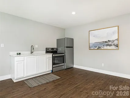 a kitchen with wooden floors and white appliances