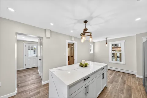 a kitchen with a sink and wooden floor