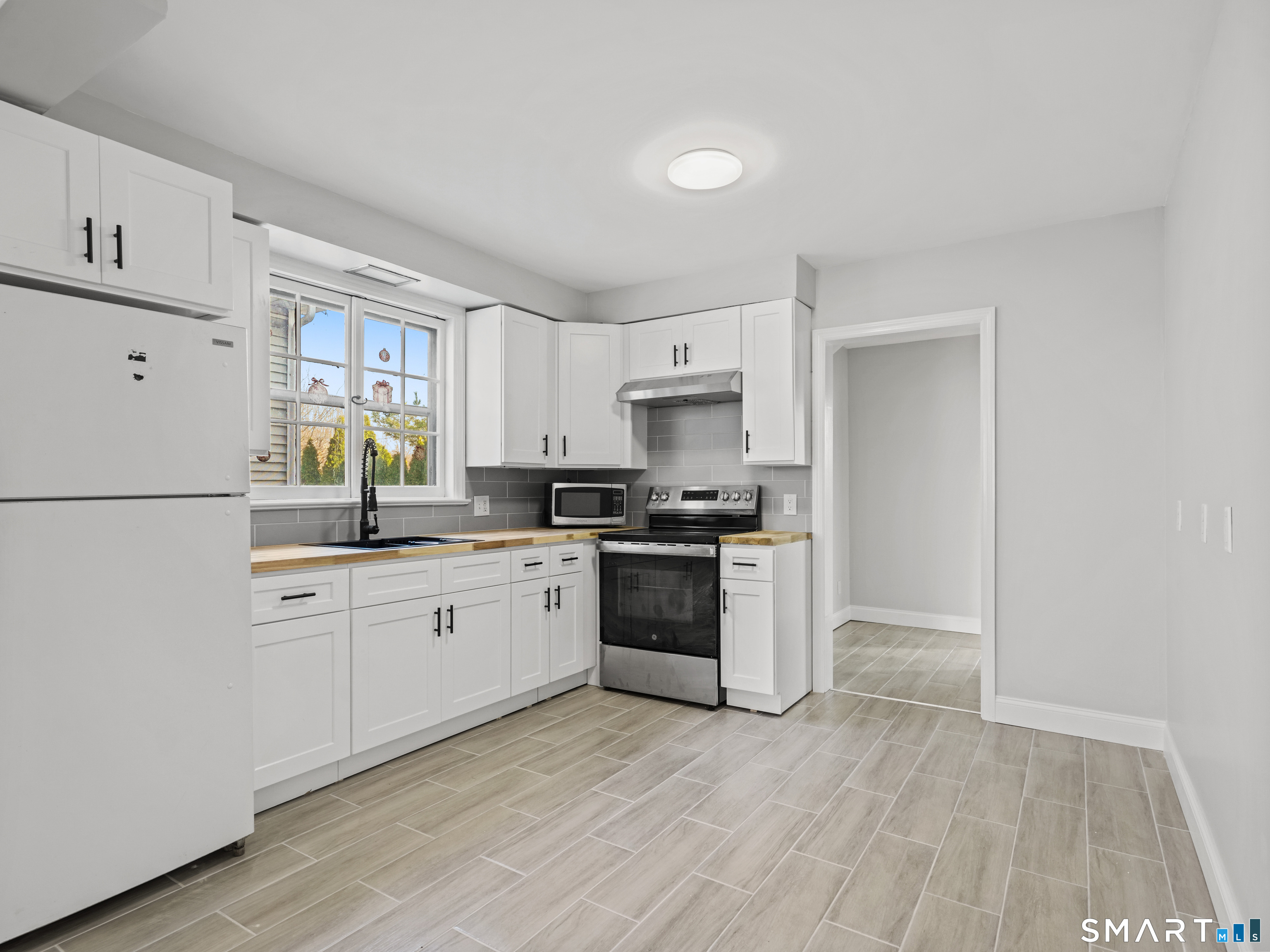 20 Cerretta Street Stamford, CT 06907 - Photo 7 of 22 a kitchen with a white cabinets and wooden floor