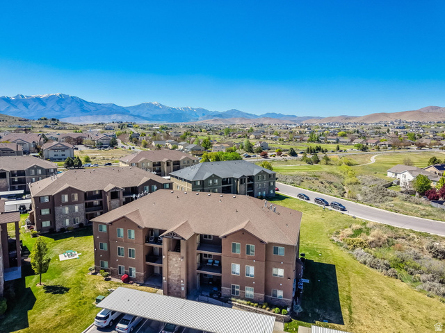 8215 Clear Rock Road, Unit 12 Eagle Mountain, UT 84005 - Photo 20 of 38 Multi-story building featuring a brown and stone-clad facade, private balconies, and covered parking
