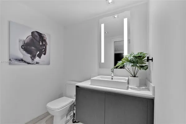 a bathroom with a toilet a sink and mirror