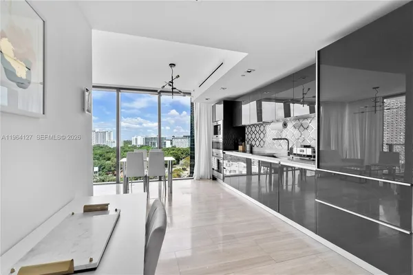 a very nice looking living room with a large window and dining table