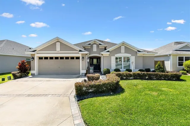 a front view of a house with a garden and yard