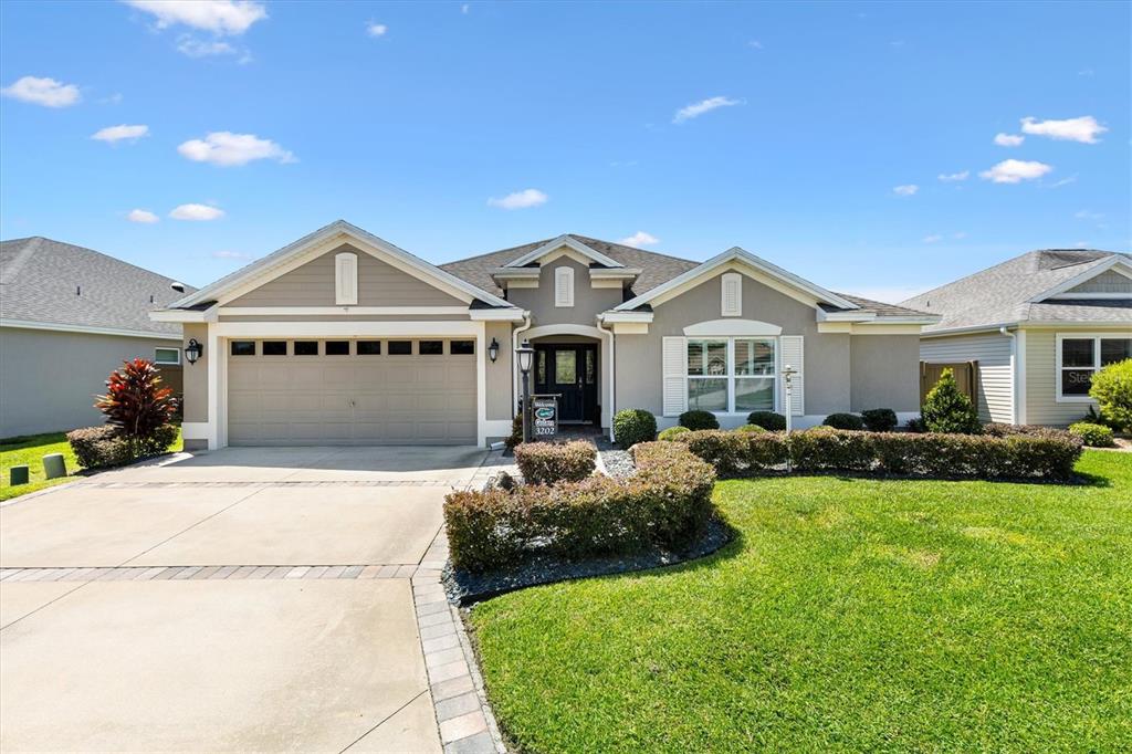 3202 Condrey Court The Villages, FL 32163 - Photo 1 of 1 a front view of a house with a garden and yard