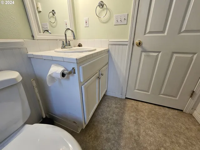 a bathroom with a sink a toilet and a mirror