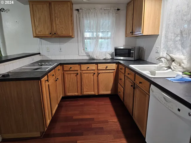 a kitchen with stainless steel appliances granite countertop wooden cabinets a sink and a stove