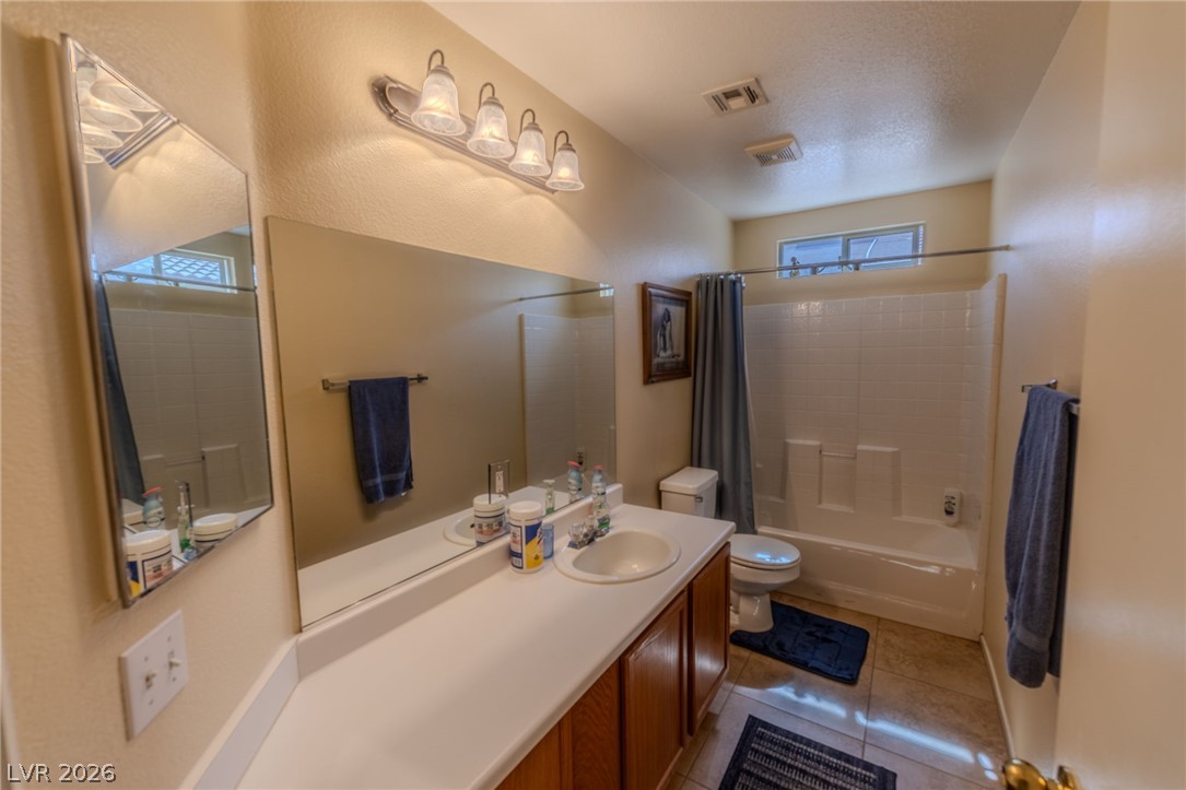 4994 Mascaro Drive Las Vegas, NV 89122 - Photo 17 of 30 A well-appointed bathroom features ample counter space, a large vanity mirror, and an accessible tub/shower combination.