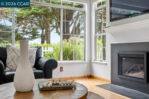 a living room with patio furniture and a fireplace