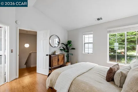 a bedroom with a bed a mirror and a window