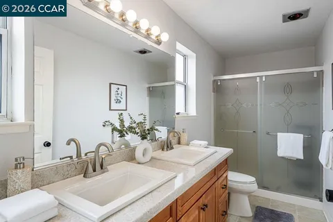 a bathroom with a sink vanity granite toilet and a mirror