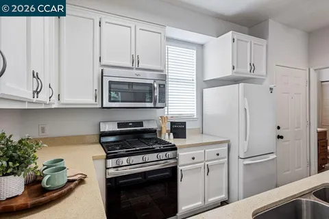 a kitchen with white cabinets and white appliances