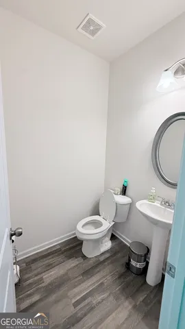a bathroom with a toilet a sink and a mirror
