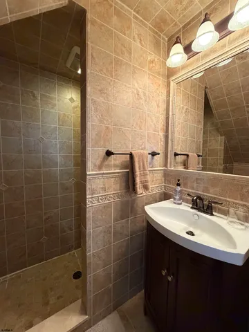 a bathroom with a sink shower and a mirror
