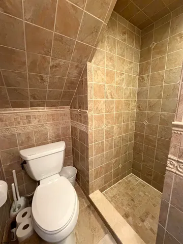 a bathroom with a toilet and a shower