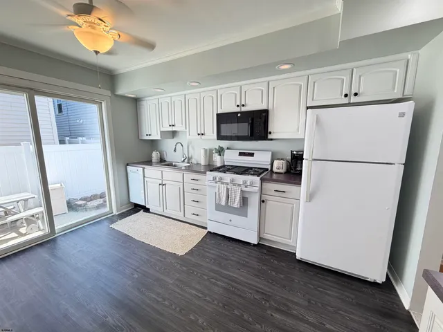 a kitchen with cabinets wooden floor and stainless steel appliances