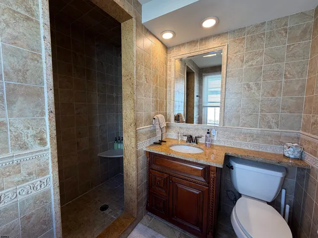a bathroom with a double vanity sink toilet and shower
