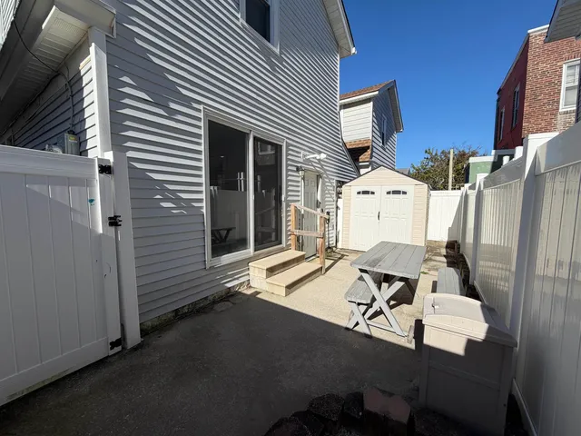 a view of a patio with table and chairs with wooden floor and fence