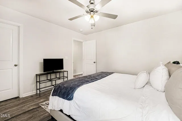 a bedroom with a large bed and a chandelier