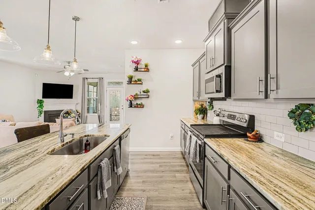 a kitchen with stainless steel appliances granite countertop a sink stove and refrigerator
