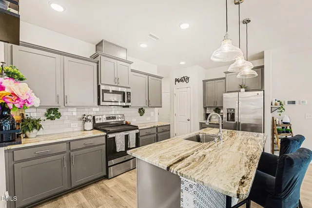 a kitchen with stainless steel appliances sink stove microwave and cabinets