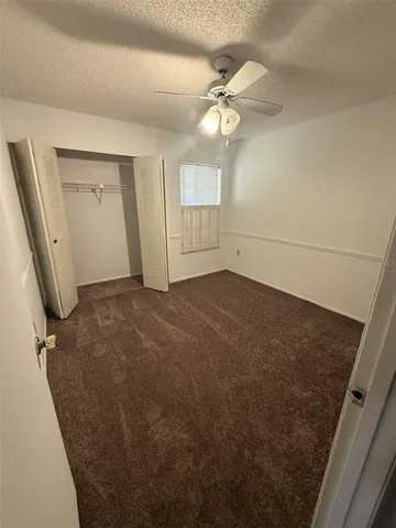 en empty room with windows and ceiling fan