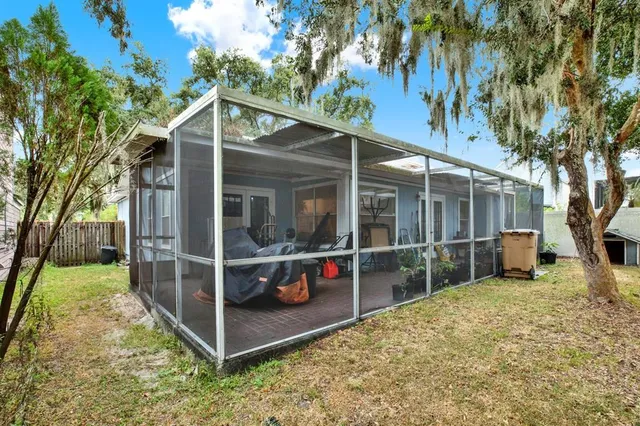 a view of a house with wooden walls and a yard