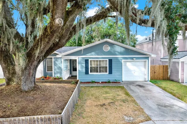 a front view of house with yard and trees around