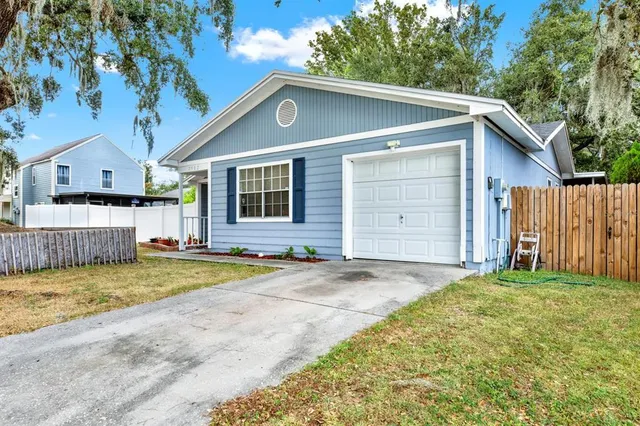 a view of a house with a yard and large tree