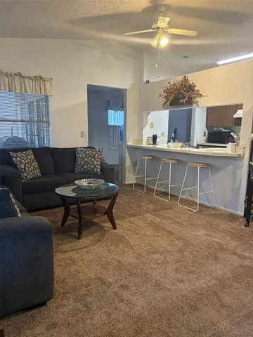 a living room with furniture and view of kitchen