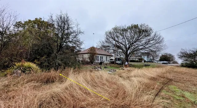 a backyard of a house with fountain table and chairs