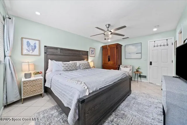 a bedroom with a bed flat screen tv and a chandelier