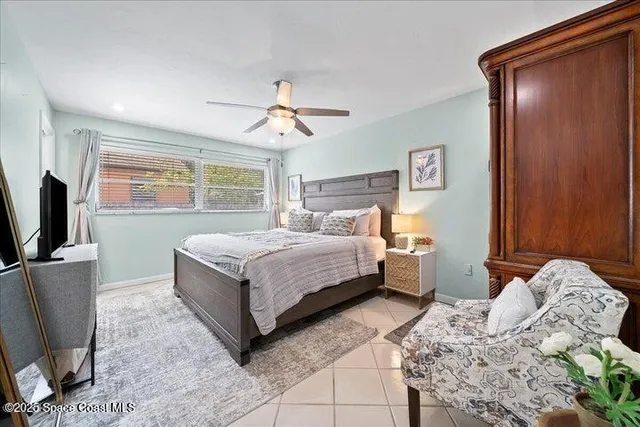 a bedroom with a large bed and a flat tv screen on dresser