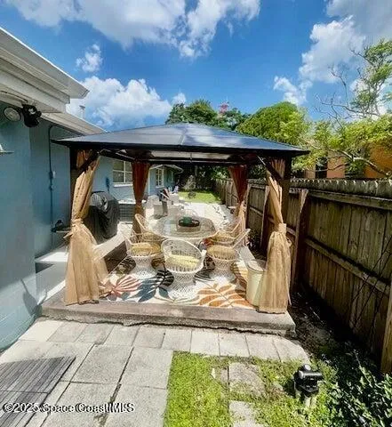 a view of a porch with furniture and floor to ceiling window