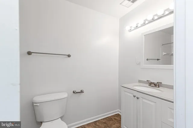 a bathroom with a granite countertop toilet and sink