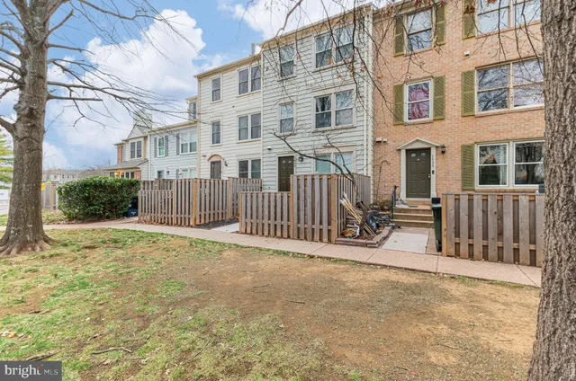 a view of a brick house with many windows next to a yard