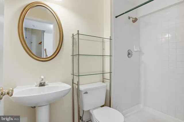 a bathroom with a sink toilet and a mirror
