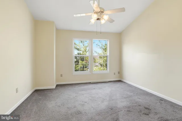 an empty room with a window and a fan