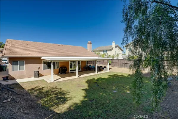 a view of a house with a big yard and large tree