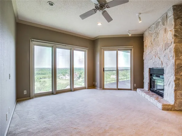 a view of an empty room with a fireplace and a window