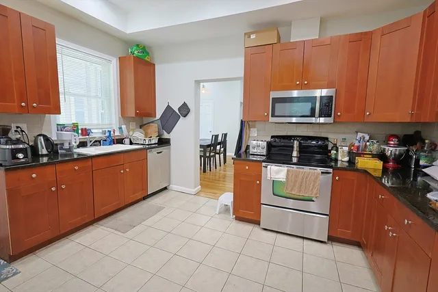 a kitchen with stainless steel appliances a sink a stove a microwave a sink a refrigerator and cabinets