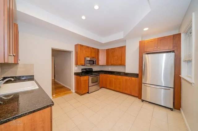 a kitchen with stainless steel appliances a sink stove refrigerator and cabinets