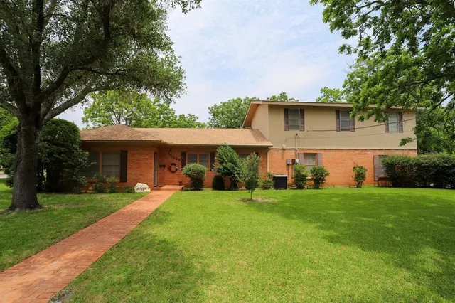 a front view of house with yard and trees