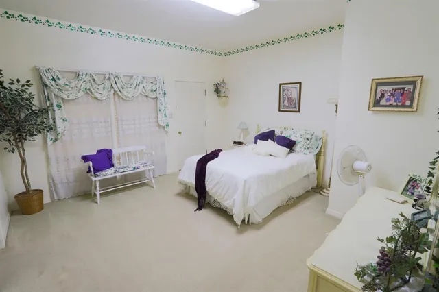 a bedroom with a bed and a potted plant