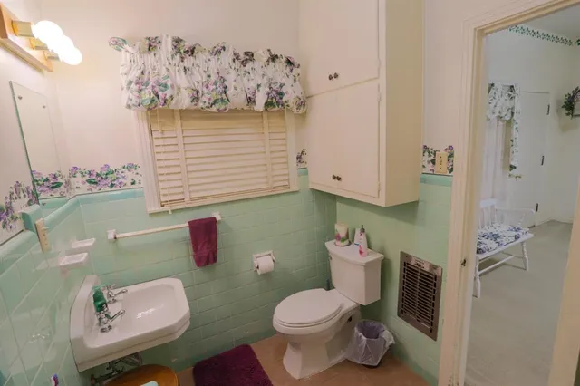 a bathroom with a toilet sink and mirror