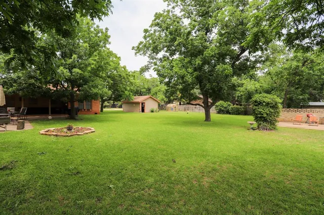 a backyard of a house with plants and barbeque oven