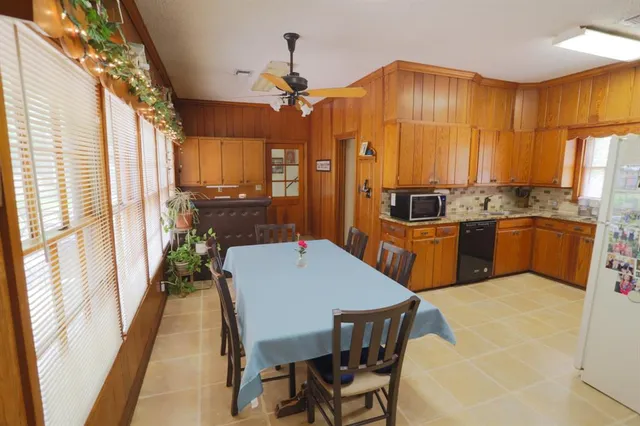 a kitchen with granite countertop a sink a counter space appliances and cabinets
