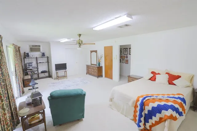 a bedroom with a bed furniture and a flat tv screen