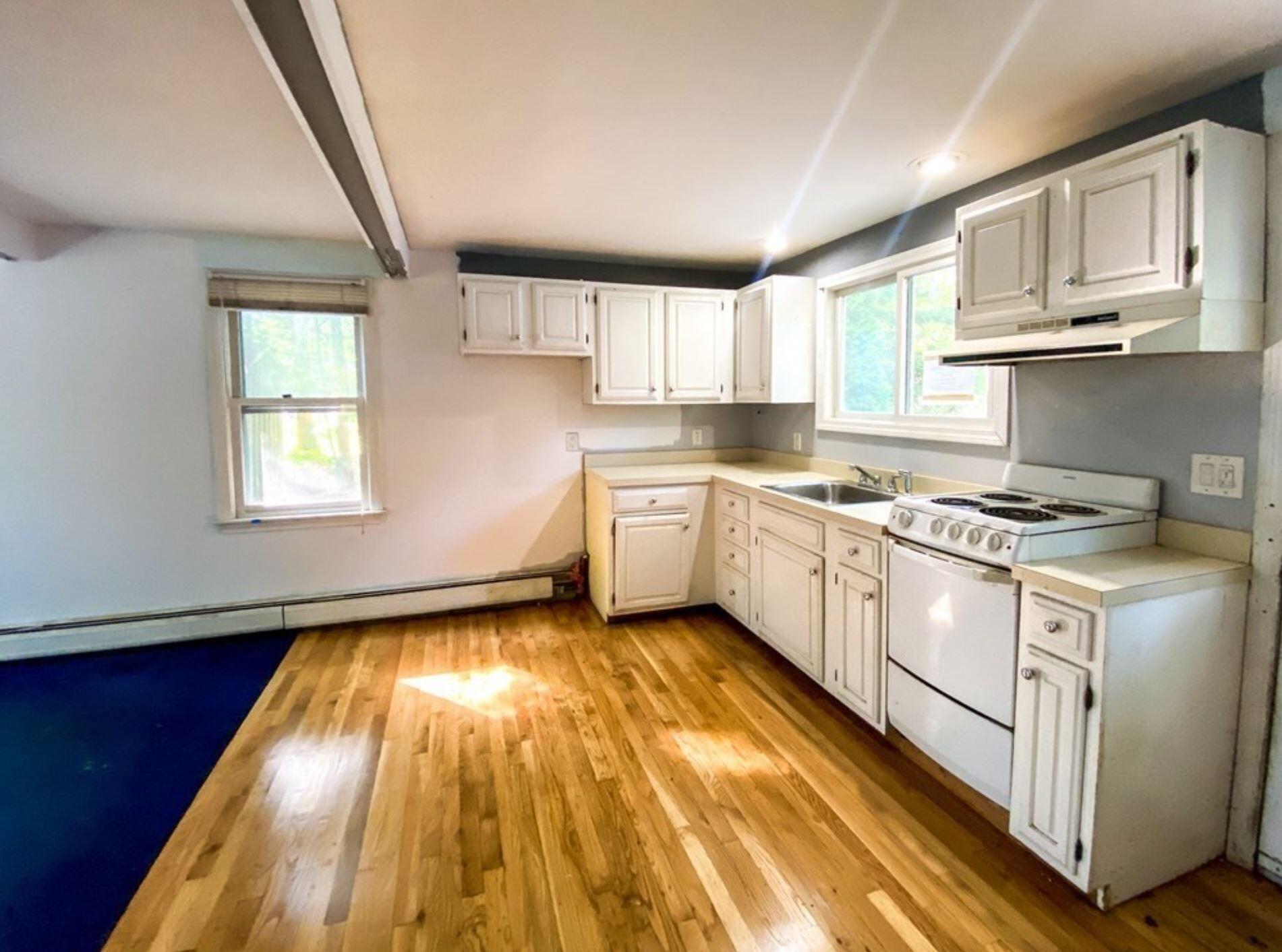 577 Lumbert Mill Road Osterville, MA 02655 - Photo 9 of 22 a kitchen with a white cabinets and wooden floor