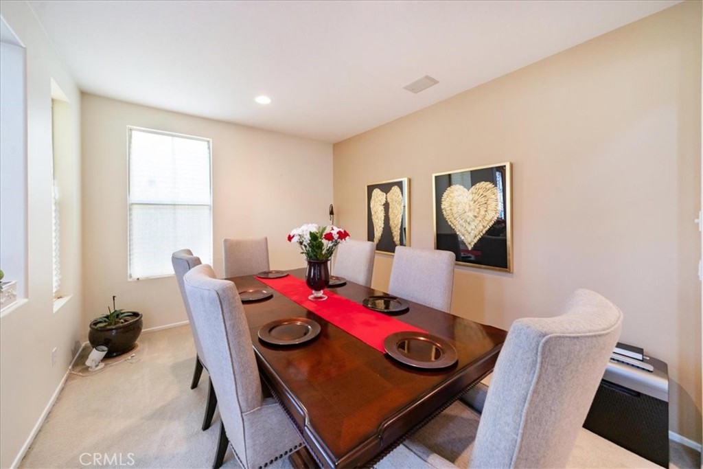 13449 Quail Run Road Eastvale, CA 92880 - Photo 17 of 59 a view of a dining room with furniture and a potted plant