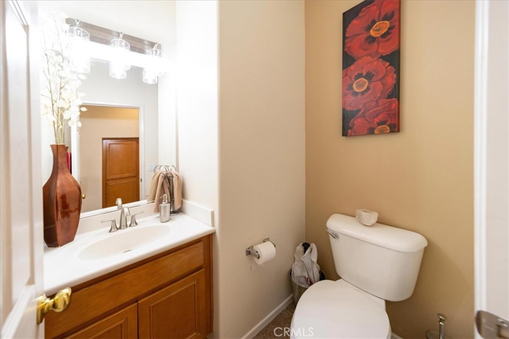13449 Quail Run Road Eastvale, CA 92880 - Photo 32 of 59 a bathroom with a toilet sink and mirror